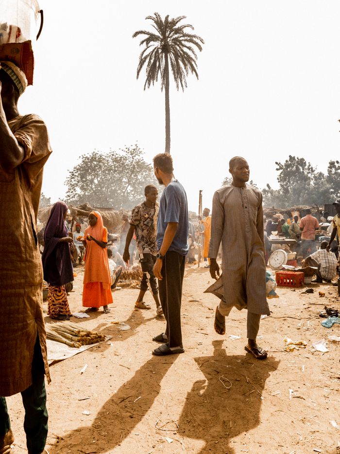 A bustling market day with diverse people under a sunny sky.