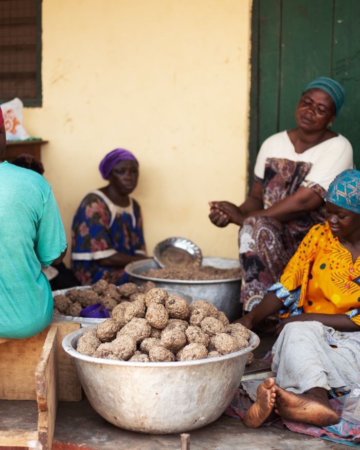 Women in colorful dresses preparing yams outdoors in Tamale, Northern Region, Ghana.